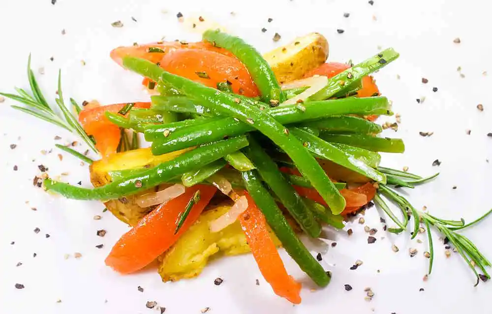 Grüner Bohnensalat mit gebratenen Frühkartoffeln, Tomatenfilets und Rosmarin.