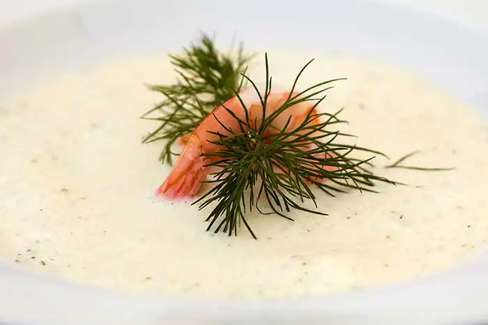 Teller mit geeister Gurkenkaltschale und Schrimps.