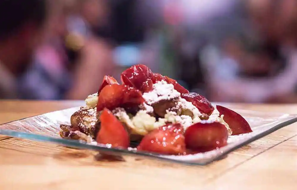 Teller mit Karamellisiertem Kaiserschmarrn an winterlicher Pflaumenkonfitüre.