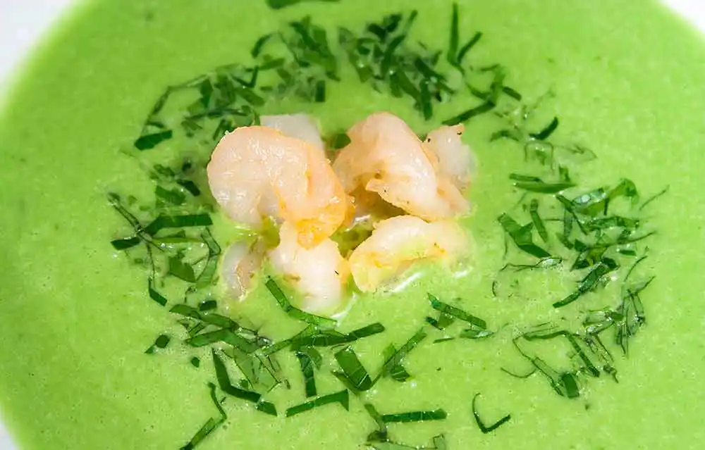Frühlingskräutersuppe mit gebratenen Garnelen.