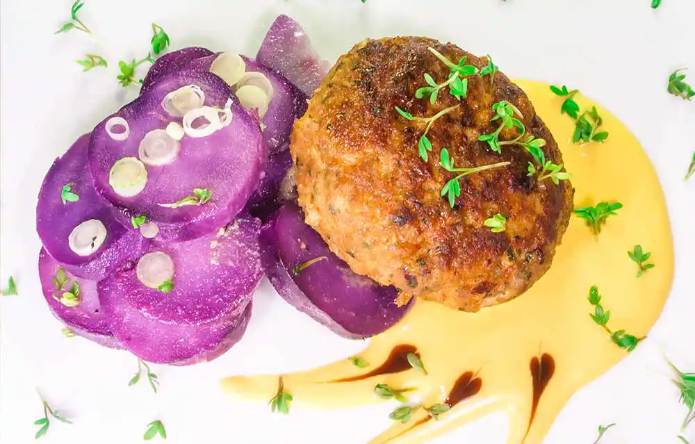 Fleischpflanzerl vom Rind und Truthahn an violettem Kartoffelsalat mit Senfcreme.
