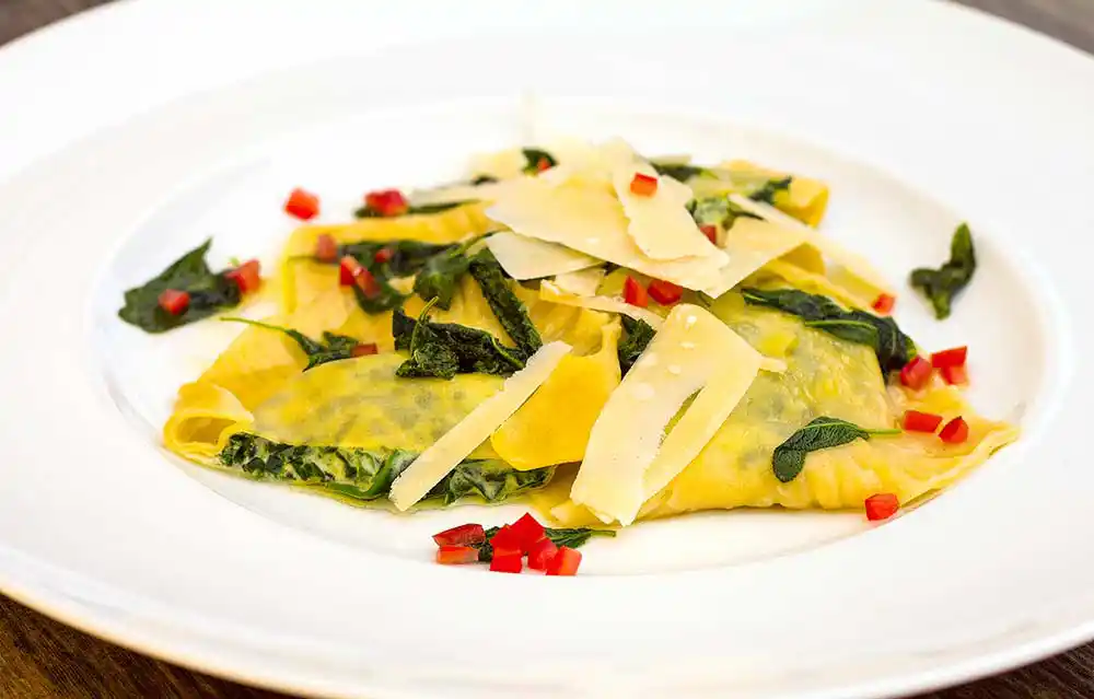 Teller mit Spinat-Ricotta-Ravioli an Salbeibutter