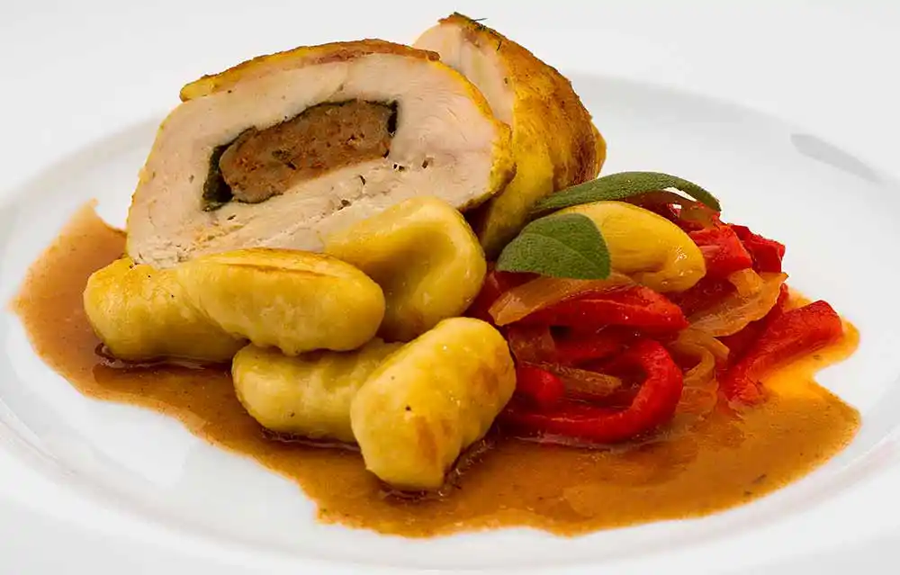 Teller mit Involtini di Pollo mit Paprikagemüse.