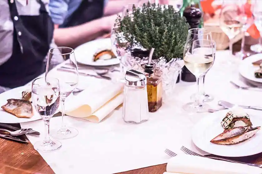 Gedeckter Tisch mit Kochkursteilnehmern.