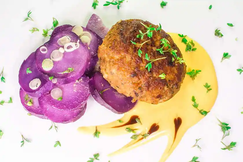 Teller mit Fleischpflanzerl und Kartoffelsalat.