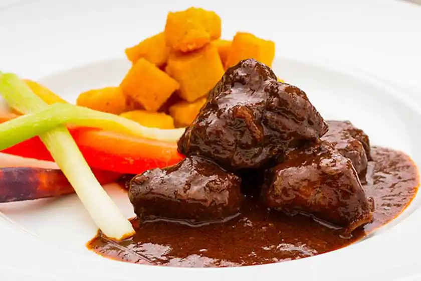 Teller mit Wildschweingulasch und Polenta.