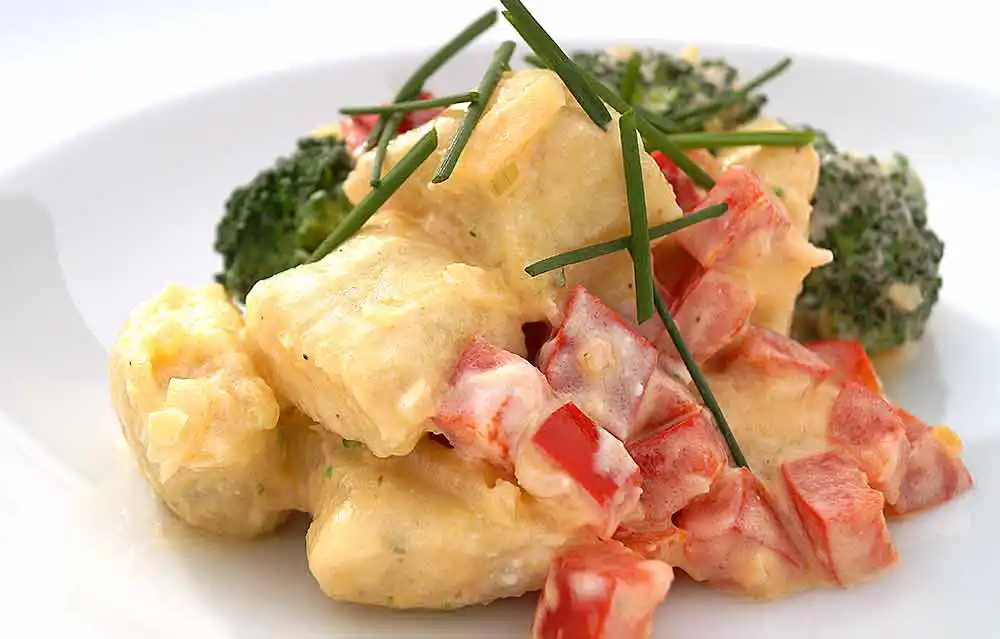 Teller mit Gnocchi-Brokkolitöpfchen mit Paprika und Frischkäse.