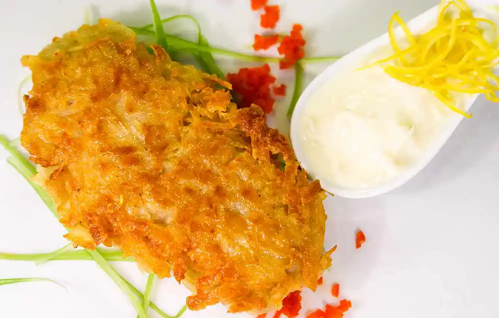 Teller mit Kabeljaufilet in der Süßkartoffelkruste gebraten auf Meerrettichsauce.