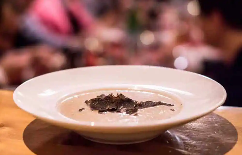 Teller mit Maronencreme-Suppe mit schwarzem Trüffel.