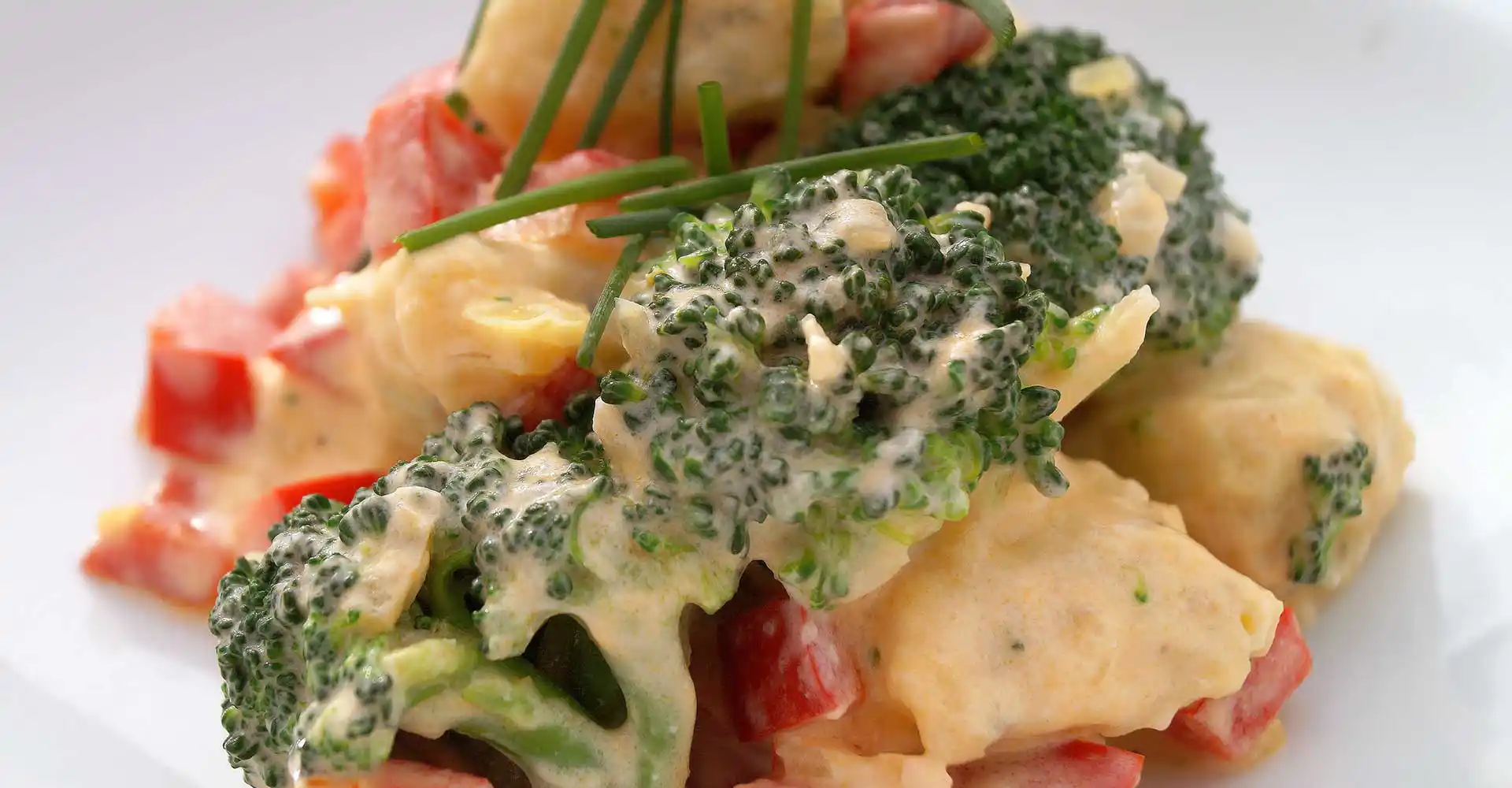 Teller mit Gnocchi-Brokkolitöpfchen mit Paprika und Frischkäse.