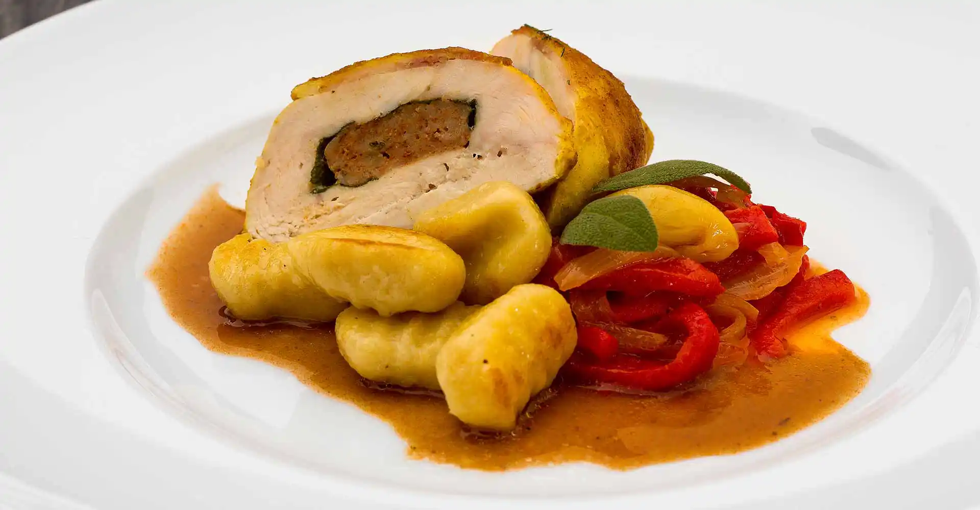 Teller mit Involtini di Pollo mit Paprikagemüse.