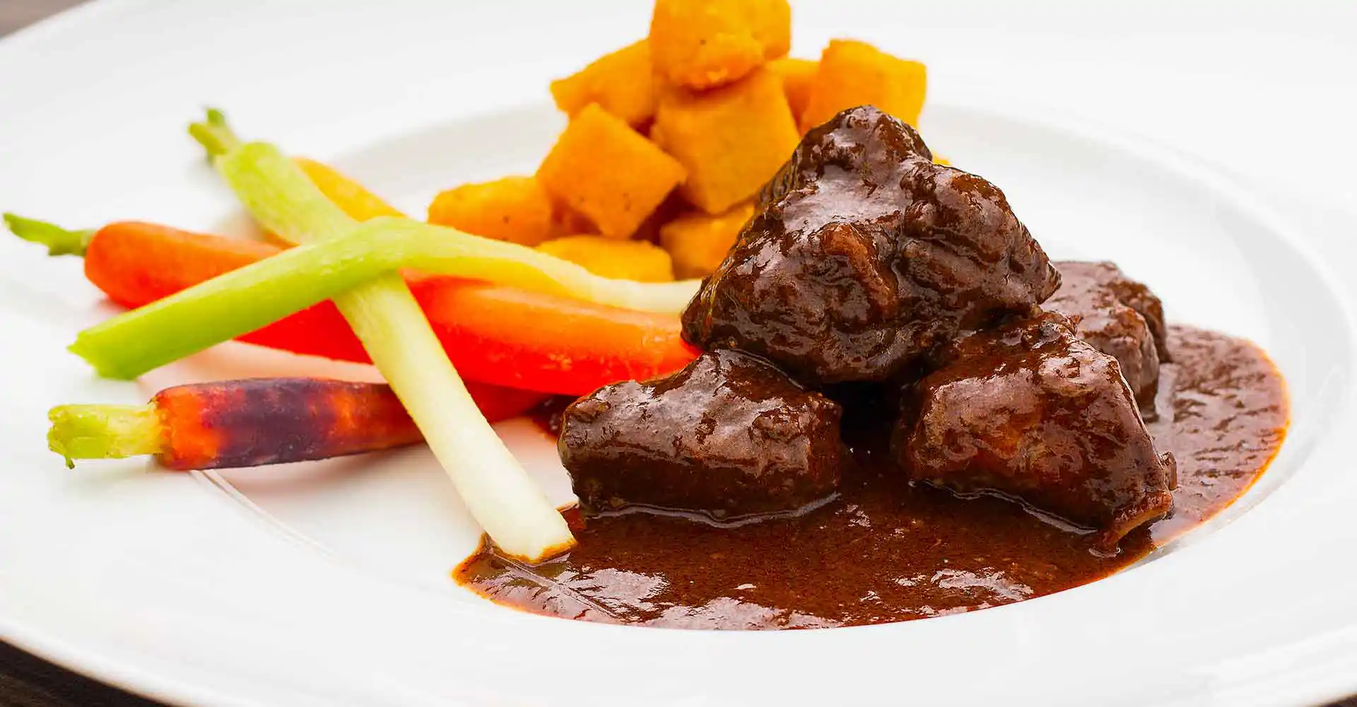Teller mit Wildschweingulasch und Polenta