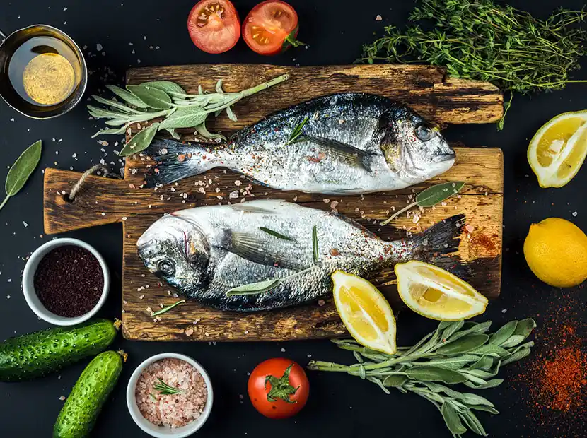 Themenkochkurs - Fische auf Holzplatte mit Kräutern