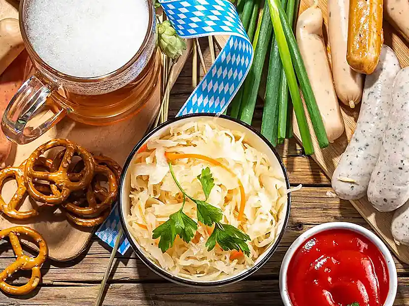Brotzeitisch mit Maß Bier, Krautsalat, Weißwürste, Brenzen.